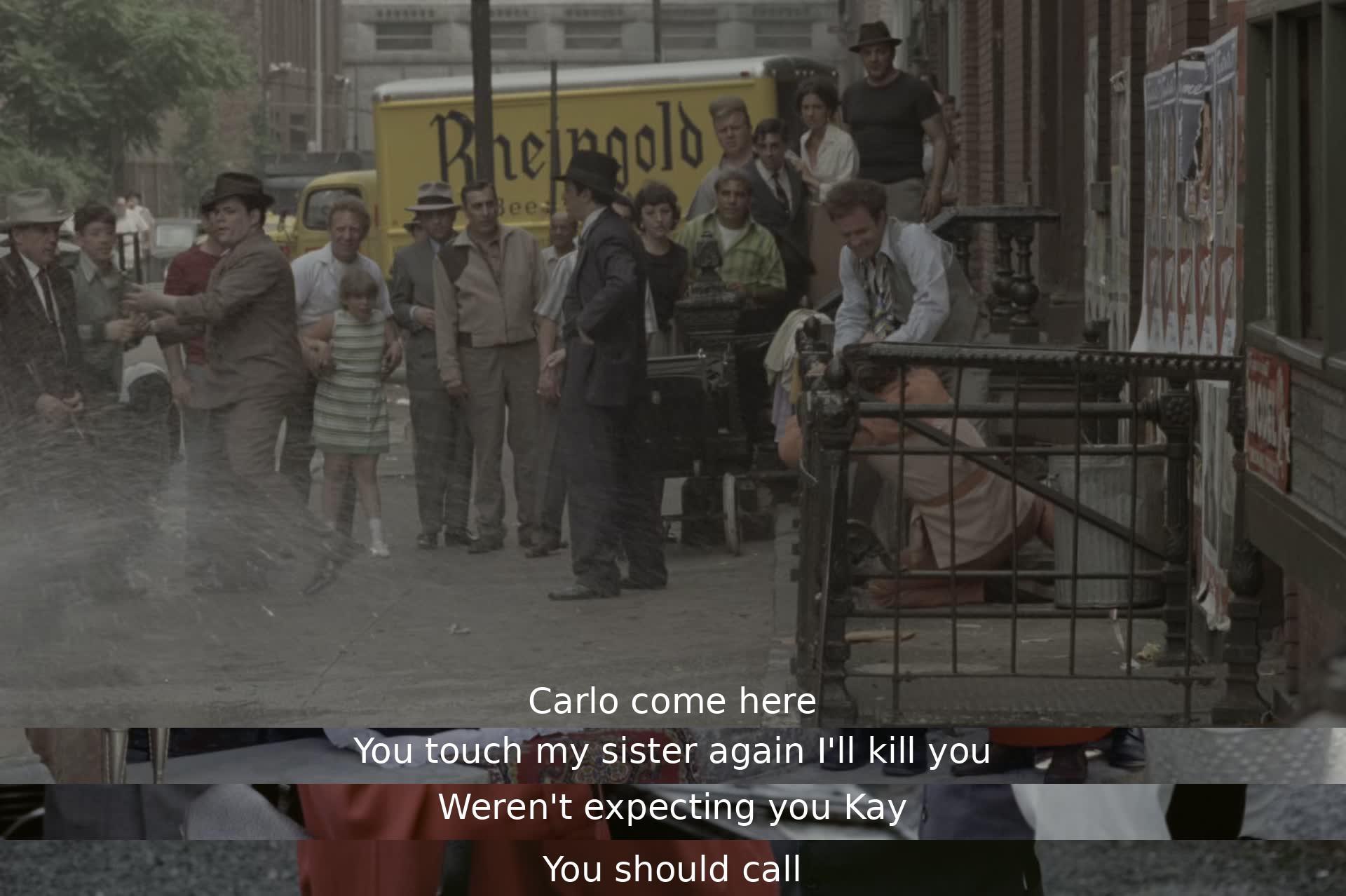 Carlo is warned not to touch the speaker's sister or face consequences. The speaker, surprised to see Kay, advises her to make a call.