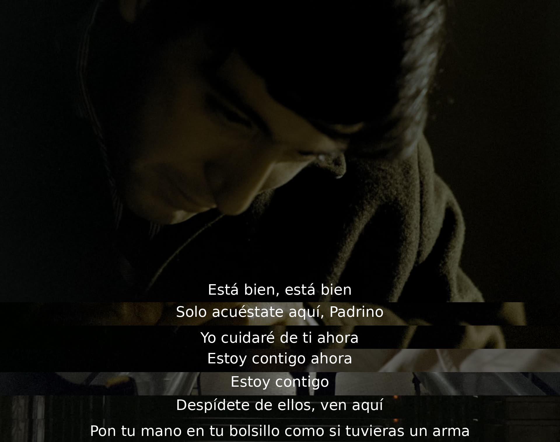 El interlocutor consuela al Padrino, diciendo que estará a su lado y se encargará de él. Luego, le indica cómo actuar para despedirse de los demás simulando tener un arma en el bolsillo. La escena transmite lealtad y cuidado en un momento tenso.