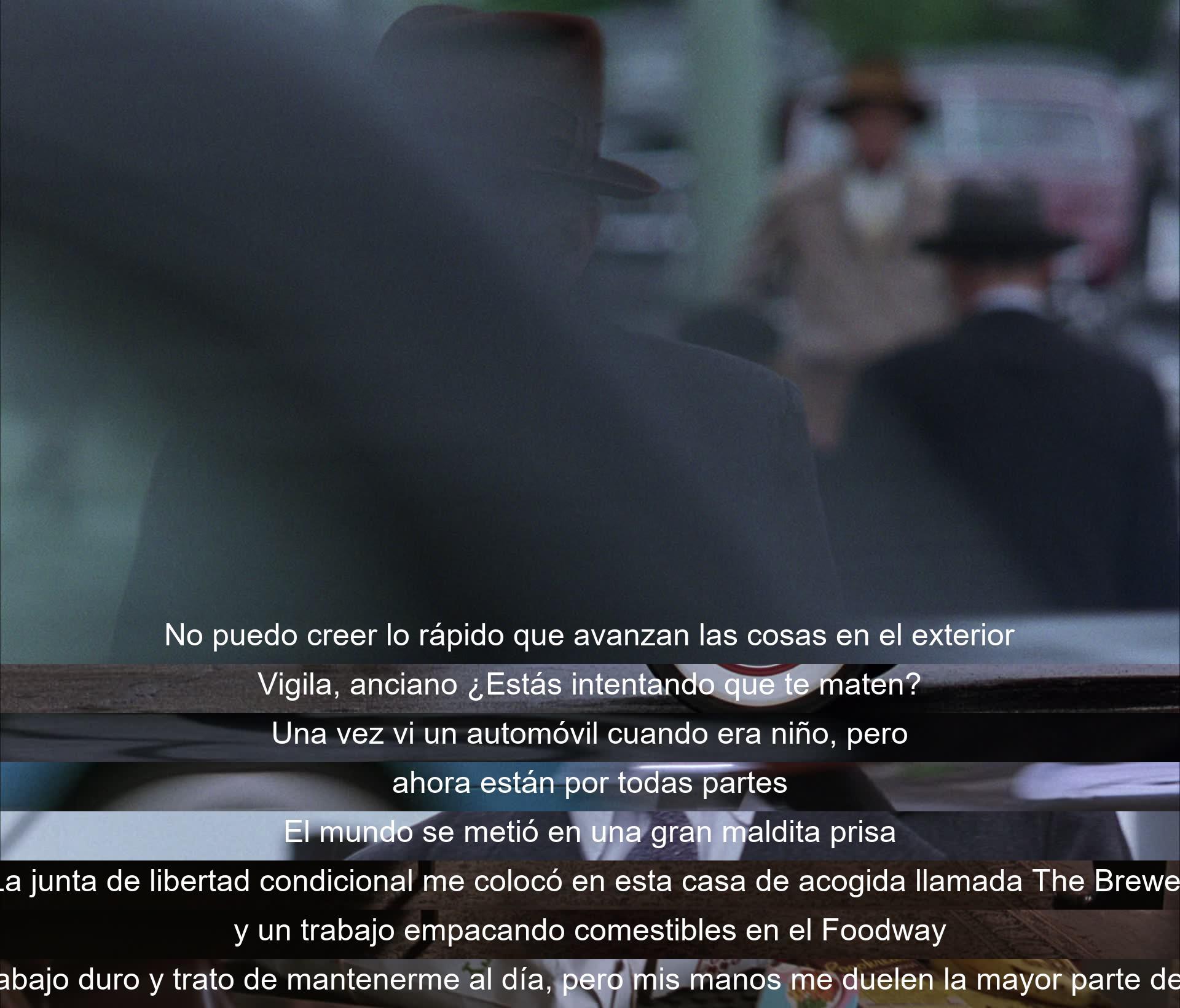 La vida exterior avanza rápido. Un hombre anciano comparte su asombro por los cambios, desde ver autos de niño hasta trabajar en una casa de acogida y en un supermercado. Aunque es difícil, se esfuerza por seguir el ritmo a pesar del dolor en sus manos.